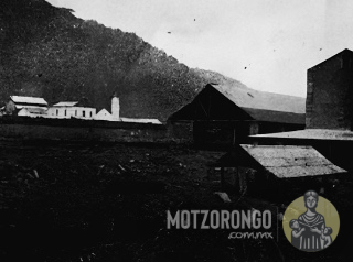Vista posterior del ingenio azucarero de Motzorongo. Observe el interruptor del ferrocarril que corre hacia el molino y el tren de carga parado frente a la tienda y la estación en la distancia.