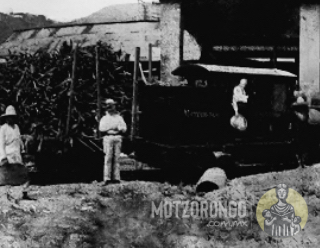 La locomotora Motzorongo del Ferrocarril Agrícola lleva góndolas de caña cargadas al molino del ingenio, Mr. Bagnall está parado en la puerta de la cabina.