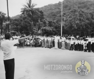 Alumnos de la Secundaria Técnica durante un desfile haciendo el juramento a la bandera en la explanada del parque "Carlos A. Pacheco" con el profesor Jesús Godínez Olmedo al frente.